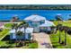 Waterfront home featuring lush landscaping, an eye-catching metal roof, and a large driveway leading to the entrance at 2019 S Riverside, Edgewater, FL 32141