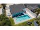 Aerial view of a private backyard oasis with a sparkling pool, patio seating, and lush landscaping at 216 Kirkland Dr, New Smyrna Beach, FL 32169