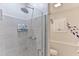 Modern bathroom with a glass shower enclosure and tiled walls, alongside a toilet and storage cabinet at 216 Kirkland Dr, New Smyrna Beach, FL 32169