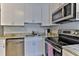 Modern kitchen features stainless steel appliances, granite countertops, and white cabinetry at 216 Kirkland Dr, New Smyrna Beach, FL 32169