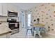 Charming kitchen with white cabinets, stainless steel appliances, and a cozy dining area at 216 Kirkland Dr, New Smyrna Beach, FL 32169