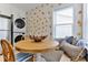 This well-lit kitchenette features laundry machines, an adjacent breakfast nook and citrus-themed wallpaper at 216 Kirkland Dr, New Smyrna Beach, FL 32169