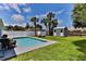 Beautiful pool area with a storage shed, lounge chairs, and lush landscaping at 216 Kirkland Dr, New Smyrna Beach, FL 32169