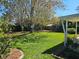 Large grassy backyard with mature trees offering shade and privacy, perfect for outdoor activities at 2321 Tamarind Dr, Edgewater, FL 32141