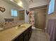 Bathroom with a vanity, sink, mirror, and shower-tub combination and neutral tiling at 2321 Tamarind Dr, Edgewater, FL 32141