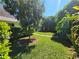Serene front yard featuring a mature tree, well-kept lawn, and lush greenery at 2321 Tamarind Dr, Edgewater, FL 32141