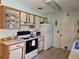 Cozy kitchen featuring white appliances and wood-trimmed cabinetry and tile floors at 2321 Tamarind Dr, Edgewater, FL 32141