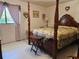 Bedroom with a four-poster bed, floral bedding and decor, and natural light from a window at 2321 Tamarind Dr, Edgewater, FL 32141