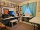 Home office with multiple workstations, shelving units, and ample lighting at 2321 Tamarind Dr, Edgewater, FL 32141