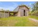 Rustic barn featuring wide sliding doors and adjacent paddock at 2533 Glenhaven St, New Smyrna Beach, FL 32168