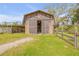 Rustic barn featuring wide sliding doors and adjacent paddock at 2533 Glenhaven St, New Smyrna Beach, FL 32168