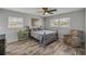 Comfortable bedroom featuring wood-look floors, ceiling fan, and a cozy chair at 2533 Glenhaven St, New Smyrna Beach, FL 32168