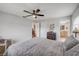 Neutral bedroom boasts modern ceiling fan with adjoining bathroom and kitchen views at 2533 Glenhaven St, New Smyrna Beach, FL 32168