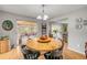 Bright dining room with a round wooden table and views to the lanai at 2533 Glenhaven St, New Smyrna Beach, FL 32168