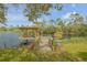 Charming wooden dock on the lake features a covered seating area perfect for enjoying the serene waterfront views at 2533 Glenhaven St, New Smyrna Beach, FL 32168