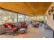 Inviting sunroom featuring wicker furniture, wood ceiling and serene views of the property and lake at 2533 Glenhaven St, New Smyrna Beach, FL 32168