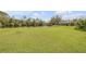 Expansive green lawn leading to a serene pond and barn at 2533 Glenhaven St, New Smyrna Beach, FL 32168