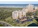 Aerial view of condos near the ocean, highlighting the building's proximity to the beach, dunes, and green spaces at 261 Minorca Beach Way # 606, New Smyrna Beach, FL 32169