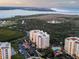 Aerial view of condo complex showcasing resort-style amenities, pool, tennis courts, and prime coastal location at 261 Minorca Beach Way # 606, New Smyrna Beach, FL 32169