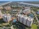 Overhead shot of condo buildings near the intercoastal, featuring a pool, tennis courts, and lush green surroundings at 261 Minorca Beach Way # 606, New Smyrna Beach, FL 32169
