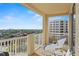 Enjoy the outside on this spacious balcony with a view of palm trees, a manicured lawn, and another building at 261 Minorca Beach Way # 606, New Smyrna Beach, FL 32169