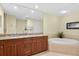 Elegant bathroom featuring double vanity with granite countertop and soaking tub at 261 Minorca Beach Way # 606, New Smyrna Beach, FL 32169