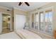 Bedroom with ceiling fan, balcony access through shuttered glass doors, and adjacent bathroom at 261 Minorca Beach Way # 606, New Smyrna Beach, FL 32169