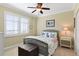Cozy bedroom with a ceiling fan, nautical themed decor, and shuttered windows at 261 Minorca Beach Way # 606, New Smyrna Beach, FL 32169