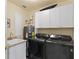 Well-equipped laundry room featuring modern washer and dryer, utility sink, and white cabinetry for ample storage at 261 Minorca Beach Way # 606, New Smyrna Beach, FL 32169