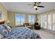 Bright main bedroom with a ceiling fan, comfortable seating, and plenty of natural light from the window at 261 Minorca Beach Way # 606, New Smyrna Beach, FL 32169