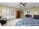 Cozy main bedroom featuring a ceiling fan, desk, comfortable furnishings, and access to a private balcony at 261 Minorca Beach Way # 606, New Smyrna Beach, FL 32169