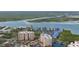 A stunning aerial view of condo buildings surrounded by lush greenery, a serene river, and well-maintained tennis courts at 2700 N Peninsula Ave # 113, New Smyrna Beach, FL 32169