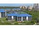 Aerial view of condos with blue roofs, green lawn, tennis courts, and Intracoastal view at 2700 N Peninsula Ave # 113, New Smyrna Beach, FL 32169