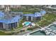 Aerial view of waterfront condos, swimming pool, boat dock, and the lush community landscape at 2700 N Peninsula Ave # 113, New Smyrna Beach, FL 32169