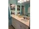 Bright bathroom vanity with light counter tops and white cabinetry below a large mirror reflecting the shower at 2700 N Peninsula Ave # 113, New Smyrna Beach, FL 32169
