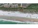 Aerial view showcases beach access via a sandy path, leading to a beautiful coastline with parked cars at 2700 N Peninsula Ave # 113, New Smyrna Beach, FL 32169