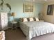 Comfortable bedroom with a decorative bed, bedside tables, and artwork adorning the light blue walls at 2700 N Peninsula Ave # 113, New Smyrna Beach, FL 32169