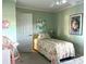 Comfortable bedroom with a twin bed, decorated with fun artwork, and a pink chair adding charm at 2700 N Peninsula Ave # 113, New Smyrna Beach, FL 32169