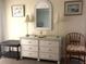 Tastefully decorated bedroom featuring a dresser with a glass top, lamps, a chair, and elegant artwork at 2700 N Peninsula Ave # 113, New Smyrna Beach, FL 32169