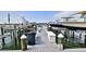 View of the community boat dock and slips, with boats parked in their designated spaces on a sunny day at 2700 N Peninsula Ave # 113, New Smyrna Beach, FL 32169