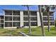Condominium's rear exterior view highlights private screened balconies and lush landscaping at 2700 N Peninsula Ave # 113, New Smyrna Beach, FL 32169
