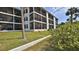 Exterior angle of a condominium's back side featuring screened balconies and lawn at 2700 N Peninsula Ave # 113, New Smyrna Beach, FL 32169