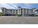 Exterior of building featuring covered parking and multiple units with balconies showcasing a well-maintained property at 2700 N Peninsula Ave # 113, New Smyrna Beach, FL 32169