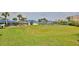 Expansive green lawn in a common area, with parking, tennis courts, and a view of the complex at 2700 N Peninsula Ave # 113, New Smyrna Beach, FL 32169