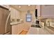 Well-lit kitchen with white cabinets, granite countertops, and stainless steel refrigerator at 2700 N Peninsula Ave # 113, New Smyrna Beach, FL 32169