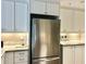 Kitchen area featuring stainless steel refrigerator and white cabinetry at 2700 N Peninsula Ave # 113, New Smyrna Beach, FL 32169
