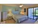 Cozy main bedroom with a queen-sized bed, dresser, and access to a private balcony at 2700 N Peninsula Ave # 113, New Smyrna Beach, FL 32169