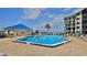 Resort-style community pool with lounge seating, an adjacent building, and a waterfront view at 2700 N Peninsula Ave # 113, New Smyrna Beach, FL 32169