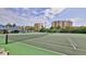 Well-maintained tennis courts with a partial view of the condo buildings and covered parking at 2700 N Peninsula Ave # 113, New Smyrna Beach, FL 32169