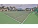 Well-maintained community tennis courts surrounded by mature trees and the condo complex at 2700 N Peninsula Ave # 113, New Smyrna Beach, FL 32169